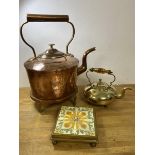 A copper kettle and trivet, kettle measures 36cm high, along with brass footed kettle with brass and