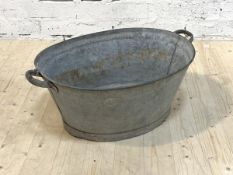 A twin handled galvanized bath tub or planter, H31cm, W80cm, D36cm