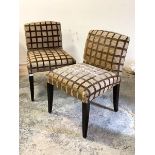 A Pair of lounge chairs, circa 1980's, upholstered in a checked tan fabric, raised on stained square