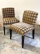 A Pair of lounge chairs, circa 1980's, upholstered in a checked tan fabric, raised on stained square