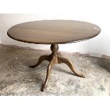 Ercol, A stained elm and beech dining table, the circular top raised on a turned column and four