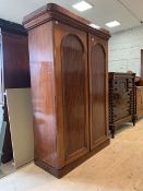 A Victorian mahogany double wardrobe, with caddy and cavetto cornice over twin arched panelled