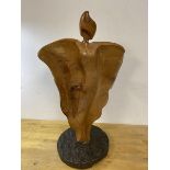 A carved stylised figure of winged woman on circular granite base measures 61cm high