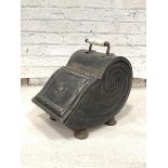 A Victorian Japanned toleware coal scuttle of shell form, with ceramic handle, gilt stencilled