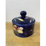 A Moorcroft lidded dish, Moorcroft imprinted to base with label W Moorcroft Potter to HM The