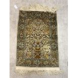 A Persian Hand knotted silk pile prayer rug, the central Mihrab with urn issuing foliate and