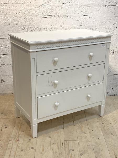 Loaf, A white painted chest fitted with three drawers, raised on square tapered supports, with