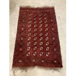 A Hand knotted Turkoman design red ground rug, with gul motif and geometric and stylised foliate