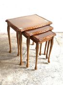 A Cherry wood nest of three tables with inset glass tops, H56cm, W55cm, D42cm