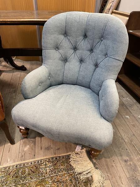 A late Victorian button back upholstered chair, raised on turned front supports with castors (One