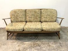 Ercol, A stained beech framed three seat sofa with upholstered squab cushions, H77cm, W170cm, D70cm