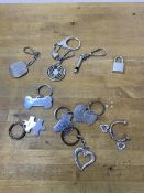 A collection of key chains, six marked silver, including a bone, puzzle piece, teddy bear, heart