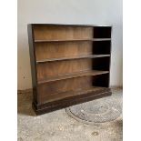 A 20th century stained pine three tier open bookcase on a plinth base, H99cm, W110cm, D23cm