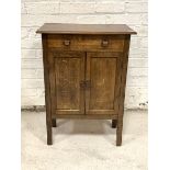 An oak cupboard, circa 1930-1940, the top over faux drawer and twin panelled cupboard doors