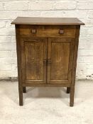 An oak cupboard, circa 1930-1940, the top over faux drawer and twin panelled cupboard doors