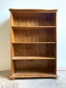 A modern polished pine floor standing bookcase with three adjustable shelves, H122cm, W86cm, D33cm