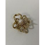 An 18ct gold diamond and pearl ribbon style brooch measures 3.5cm wide weighs 8.6grammes