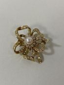 An 18ct gold diamond and pearl ribbon style brooch measures 3.5cm wide weighs 8.6grammes