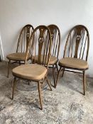 Ercol, A set of four elm and beech dining chairs, with hoop, spindle and swan carved splat back,