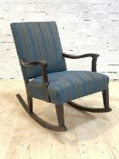 A stained walnut framed open arm rocking chair, the back and over stuffed seat upholstered in blue