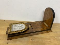 A 20thc sliding bookstand, the uprights with cherub prints, also brass plaque W N J Milne, 126