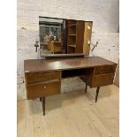 A Mid Century walnut veneered dressing table, the mirror back with twin sconces over four drawers