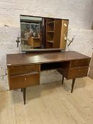A Mid Century walnut veneered dressing table, the mirror back with twin sconces over four drawers