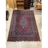 A Bidjar rug with central diamond shaped medallion on multiple flower head field and multiple