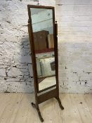 A 19thc cheval mirror, the rectangular glass in mahogany frame, on straight supports topped by urn