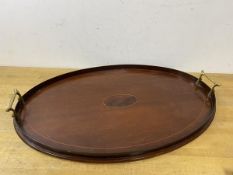 An early 20thc mahogany oval thin brass handled drinks tray, measures 38cm x 56cm