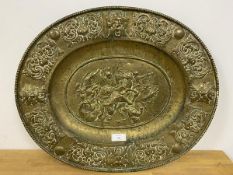 A large brass dish classically inspired with lion hunt scene in relief to well, measures 55cm x 67cm