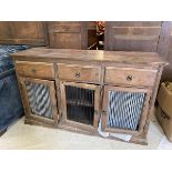 A hardwood side cabinet, the rectangular top over three short drawers, each above a grilled door,