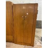 A Mid Century two-door wardrobe, interior with shelf and hanging space, on plinth base, measures