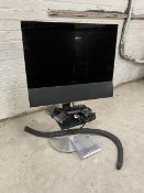 A Bang & Olufsen television with sensory swing action ability, on stand, measures 24", along with