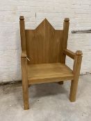 An oak monumental gothic style throne chair with arched back over rectangular seat on straight