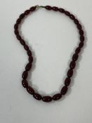 A graduated string of oval amber beads