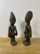 A pair of African carved wood figures, one of a man the other a woman, measures 33cm high