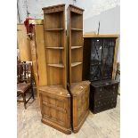 A pair of stained Ercol elm corner cabinets with three open shelves over cupboard to base,