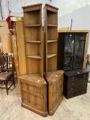 A pair of stained Ercol elm corner cabinets with three open shelves over cupboard to base,