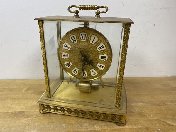 A Japanese Kundo mantel clock, glass to all four sides, gilt metal frame and dial with roman