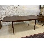 A Mid Century extending dining table with two extra leaves on turned tapering supports, measures