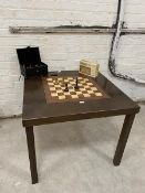 A square dining table, the central section reversible, with chequer board verso, along with a