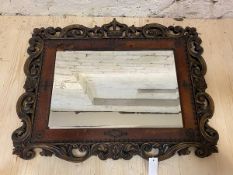 A first half of the 20thc wall mirror, the bevelled rectangular glass within a studded leather