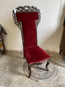 A late 19thc high back nursing chair with foliate moulding, red velvet upholstered back and seat