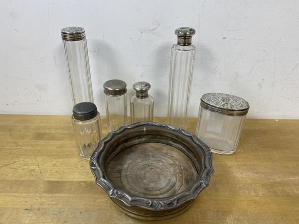 A collection of toiletry bottles, five with metal caps and a plated wine bottle coaster (a lot)