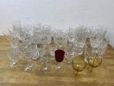 A quantity of glassware including whisky, wine, and sherry glasses, ash trays including two amber