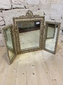 A distressed Georgian style triple swing mirror with ribbon crest over hinged central mirror flanked
