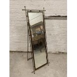 A first half of the 20thc brass framed floor standing mirror, the bevelled rectangular glass