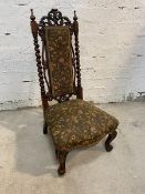 A Victorian rosewood slipper chair with intricately carved and pierced crest rail over embroidered