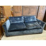 A contemporary three-seater blue velvet sofa with slightly flared arms on squat tapering square